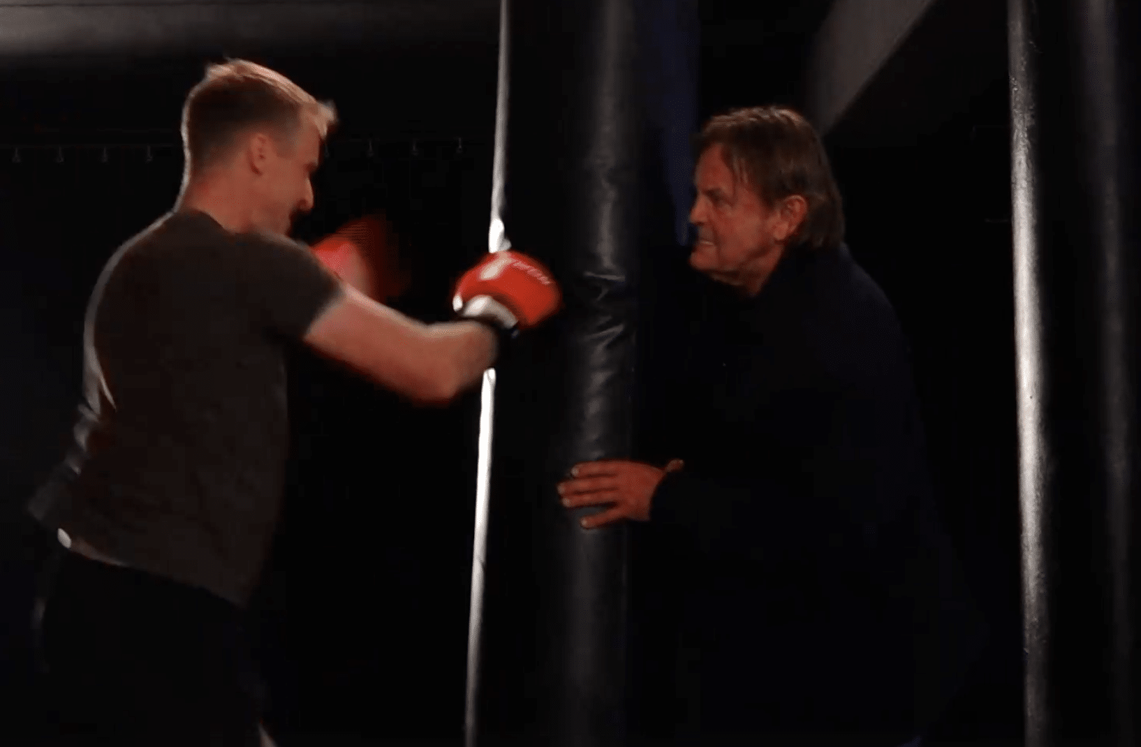 Behind the Scenes beim Kinofilm mit Tina Schüssler, Axel Schulz & Hans Ziller Peter Althof hält einen Boxsack fest auf den ein Boxer einschlägt